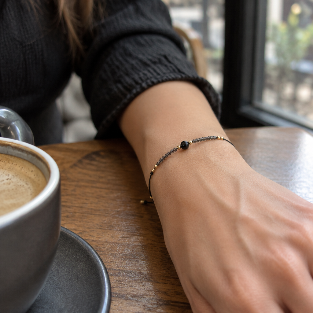 Ciemna bransoletka boho z czarnym koralikiem na nadgarstku, lifestyle restauracja